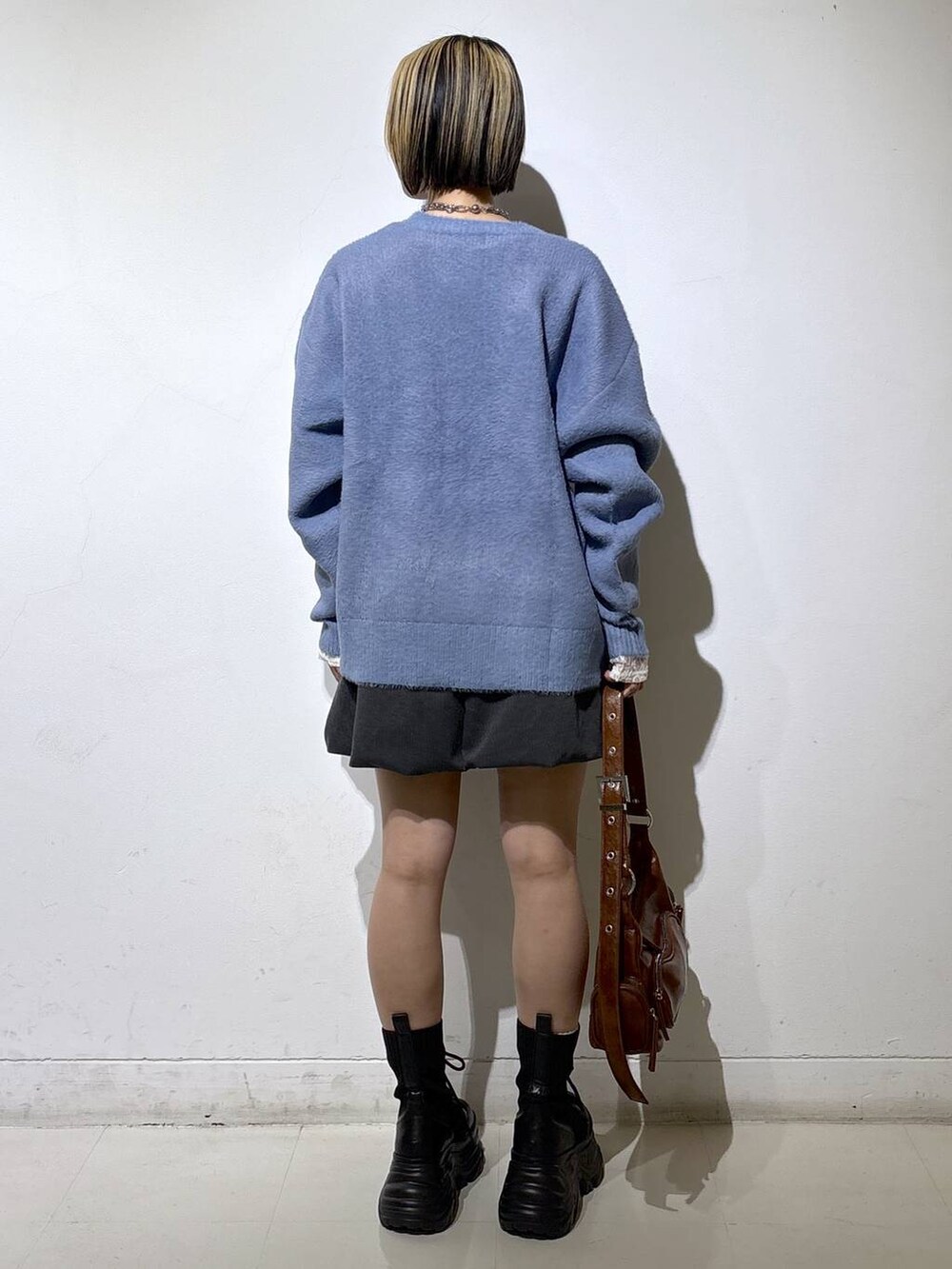 ブラック系のブーツ、ホワイト系のTシャツ/カットソー、ブラウン系のショルダーバッグを着用したレディースの冬コーディネートの4枚目の写真