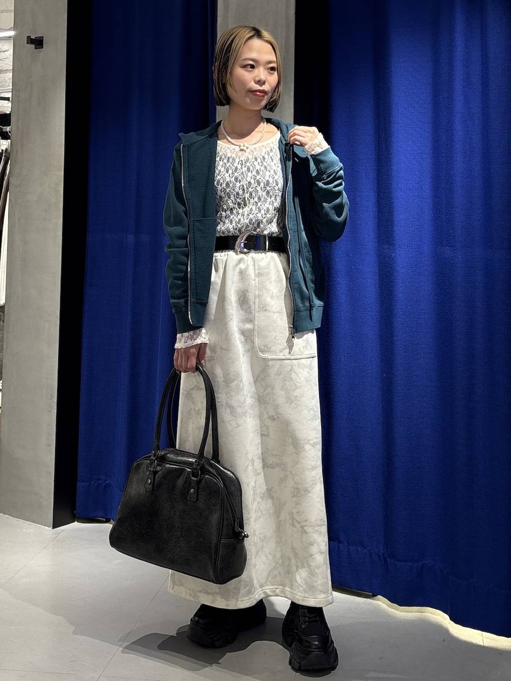 ブラック系のブーツ、ブラック系のボストンバッグ、ホワイト系のTシャツ/カットソーを着用したレディースの冬コーディネートの4枚目の写真