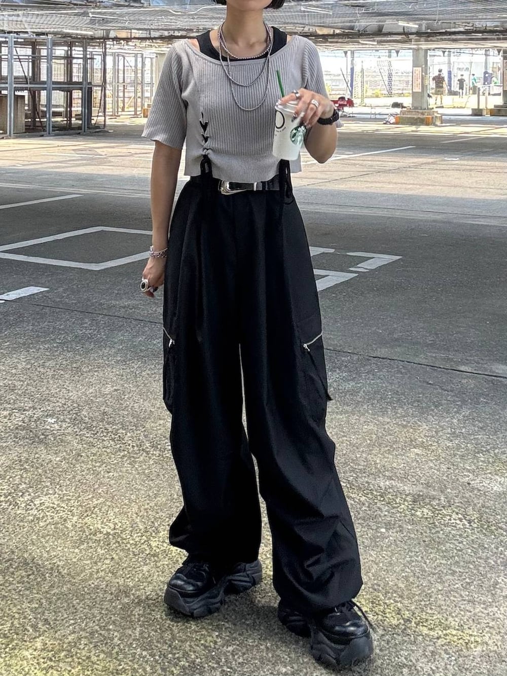 ブラック系のカーゴパンツ、グレー系のTシャツ/カットソー、ブラック系のスニーカーを着用したレディースの夏コーディネートの2枚目の写真