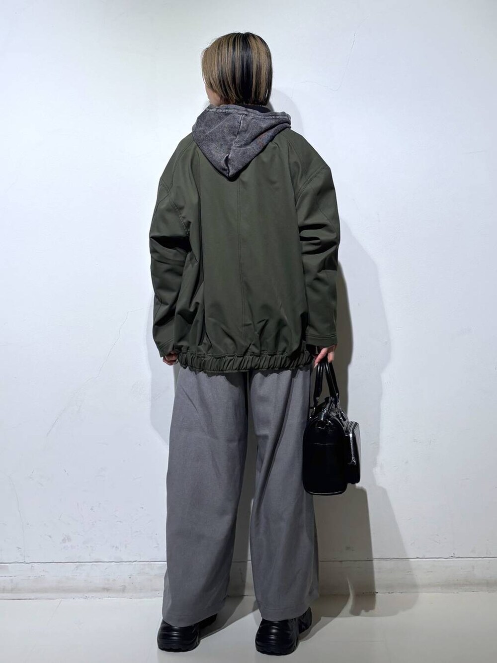 ブラック系のスニーカー、グレー系のパーカー、ブラック系のショルダーバッグを着用したレディースの春コーディネートの5枚目の写真