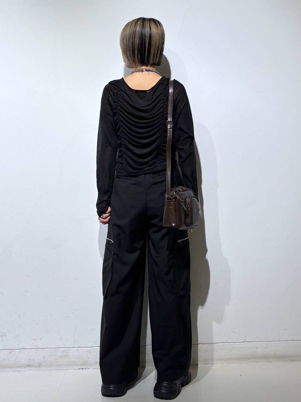 ブラック系のスニーカー、ブラック系のキャミソール、ブラック系のスラックスを着用したレディースの春コーディネートの4枚目の写真