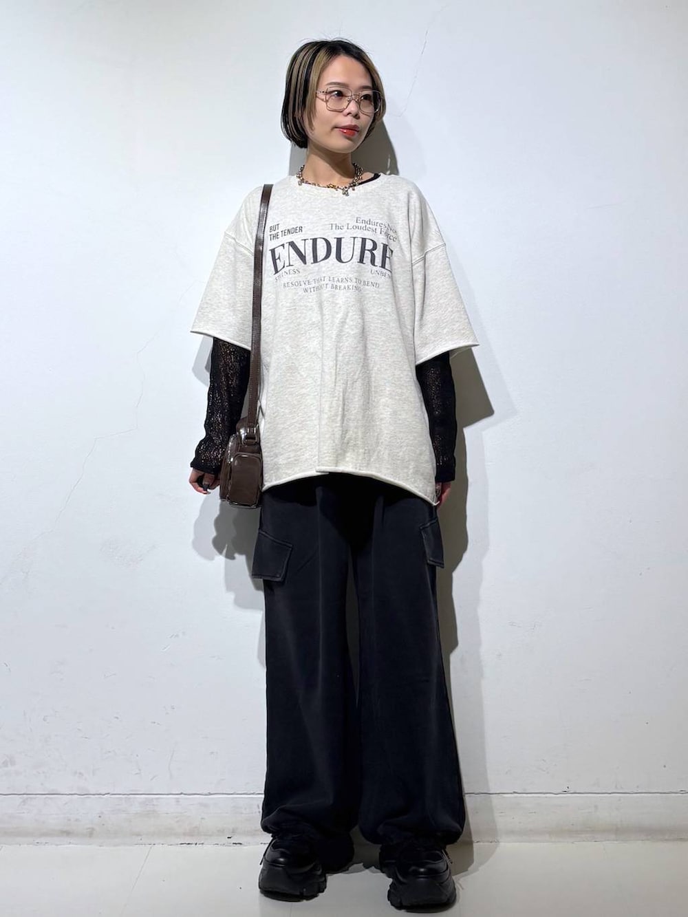 ブラック系のスニーカー、ブラウン系のショルダーバッグ、ブラック系のTシャツ/カットソーを着用したレディースの春コーディネートの6枚目の写真