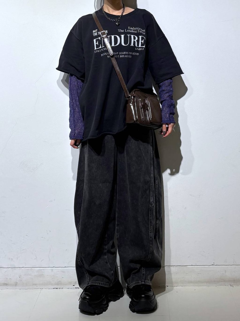 ブラック系のスニーカー、ブラウン系のショルダーバッグ、ブラック系のデニムパンツを着用したレディースの春コーディネートの3枚目の写真