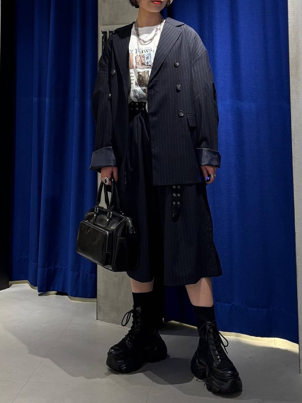 ブラック系のブーツ、ブラック系のショルダーバッグ、ホワイト系のTシャツ/カットソーを着用したレディースの春コーディネートの2枚目の写真