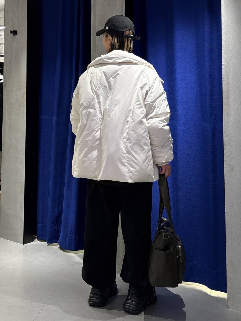 ブラック系のブーツ、グリーン系のボストンバッグ、ホワイト系のブルゾンを着用したレディースの冬コーディネートの5枚目の写真