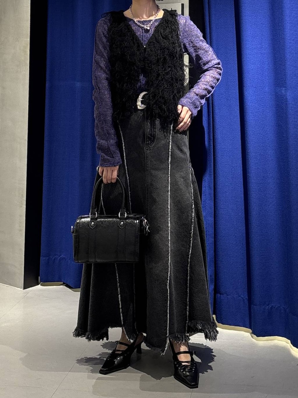 ブラック系のボストンバッグ、ブラック系のサンダル、ブラック系のデニムスカートを着用したレディースの冬コーディネートの2枚目の写真