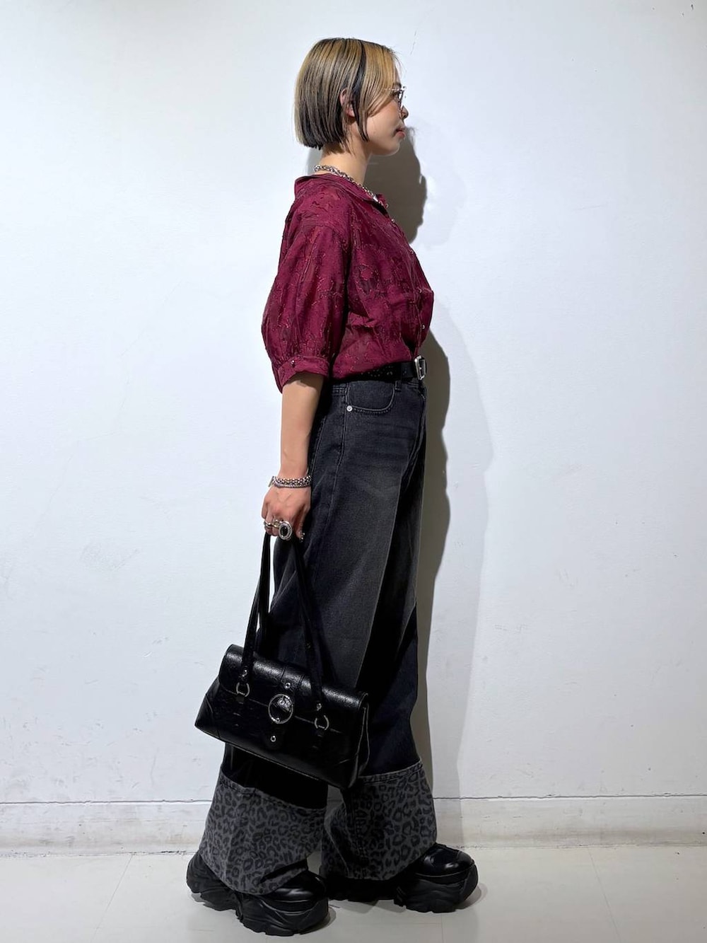 ブラック系のスニーカー、レッド系のシャツ/ブラウス、ブラック系のデニムパンツを着用したレディースの夏コーディネートの4枚目の写真