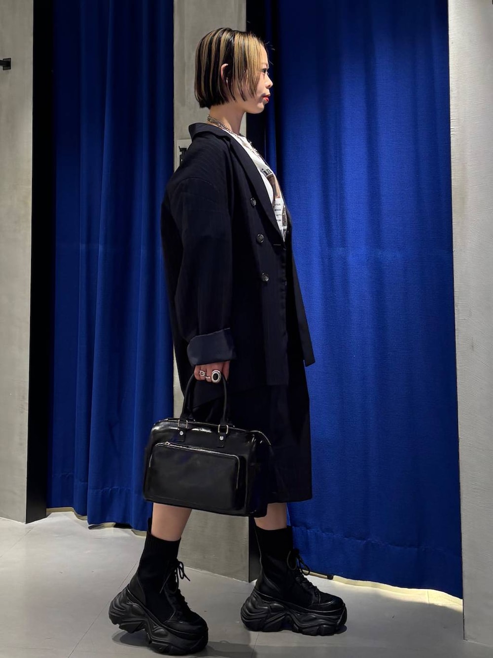 ブラック系のブーツ、ブラック系のショルダーバッグ、ホワイト系のTシャツ/カットソーを着用したレディースの春コーディネートの3枚目の写真