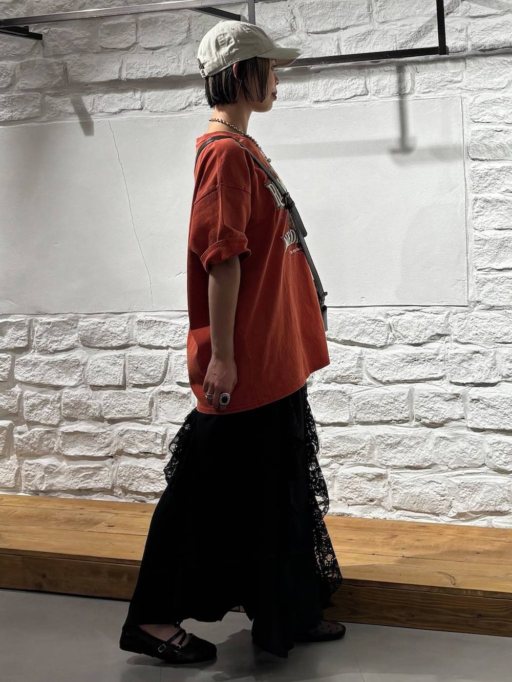 ブラウン系のショルダーバッグ、ブラック系のパンプス、レッド系のTシャツ/カットソーを着用したレディースの春コーディネートの4枚目の写真