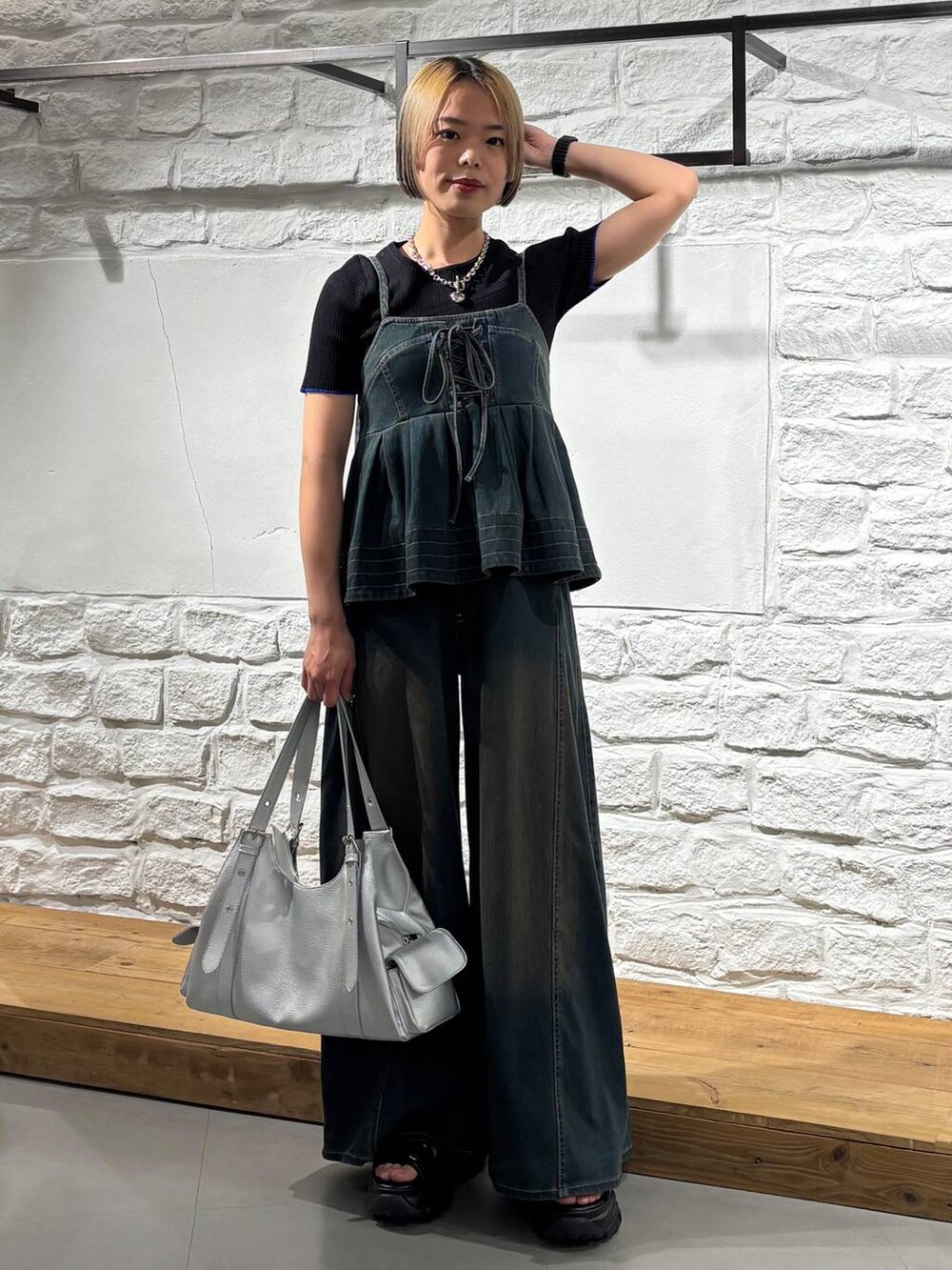 ブラック系のサンダル、シルバー系のハンドバッグ、ブラック系のTシャツ/カットソーを着用したレディースの夏コーディネートの2枚目の写真