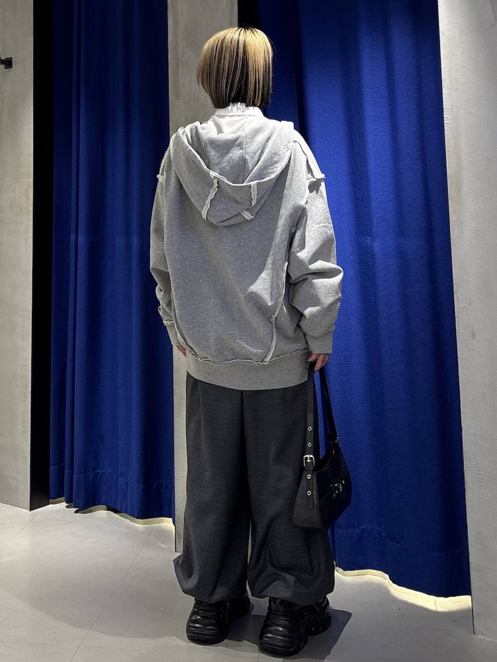 ブラック系のスニーカー、ブラック系のハンドバッグ、グレー系のその他パンツを着用したレディースの冬コーディネートの4枚目の写真