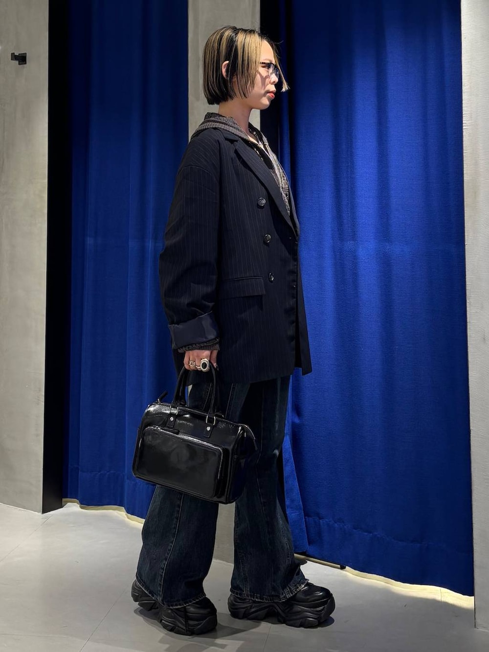 ブラック系のスニーカー、ブラック系のキャミソール、ブルー系のデニムパンツを着用したレディースの春コーディネートの3枚目の写真