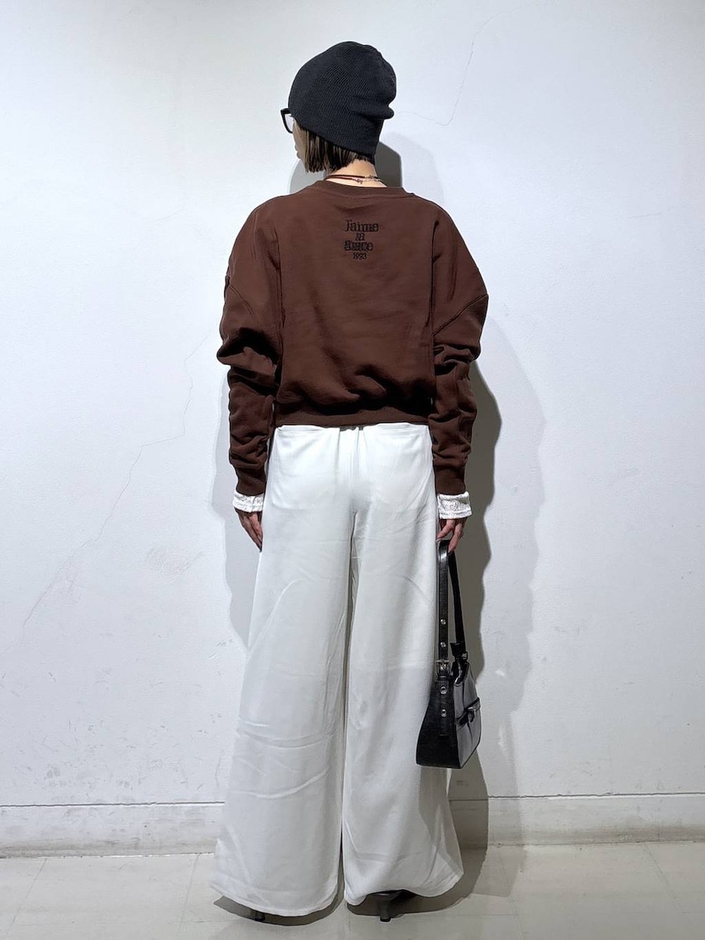 ブラウン系のスウェット、ブラック系のハンドバッグ、ブラック系のサンダルを着用したレディースの春コーディネートの5枚目の写真