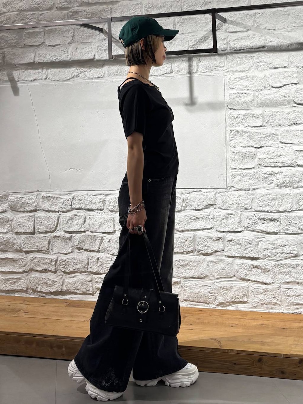 ブラック系のデニムパンツ、ブラック系のTシャツ/カットソー、ホワイト系のスニーカーを着用したレディースの夏コーディネートの5枚目の写真