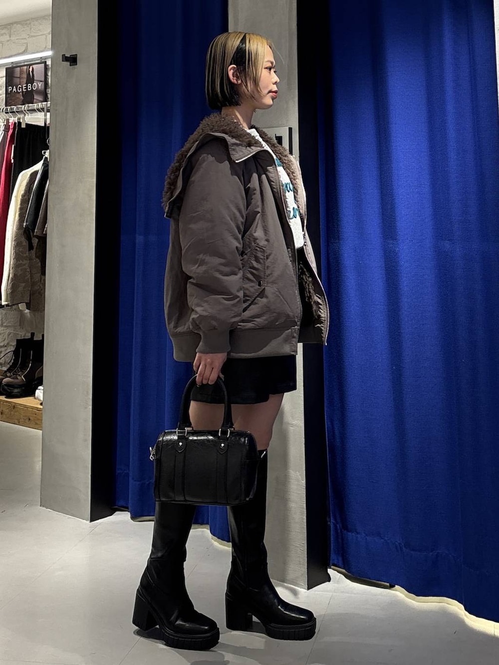 ブラック系のブーツ、ブラウン系のブルゾン、ブラック系のその他パンツを着用したレディースの冬コーディネートの5枚目の写真