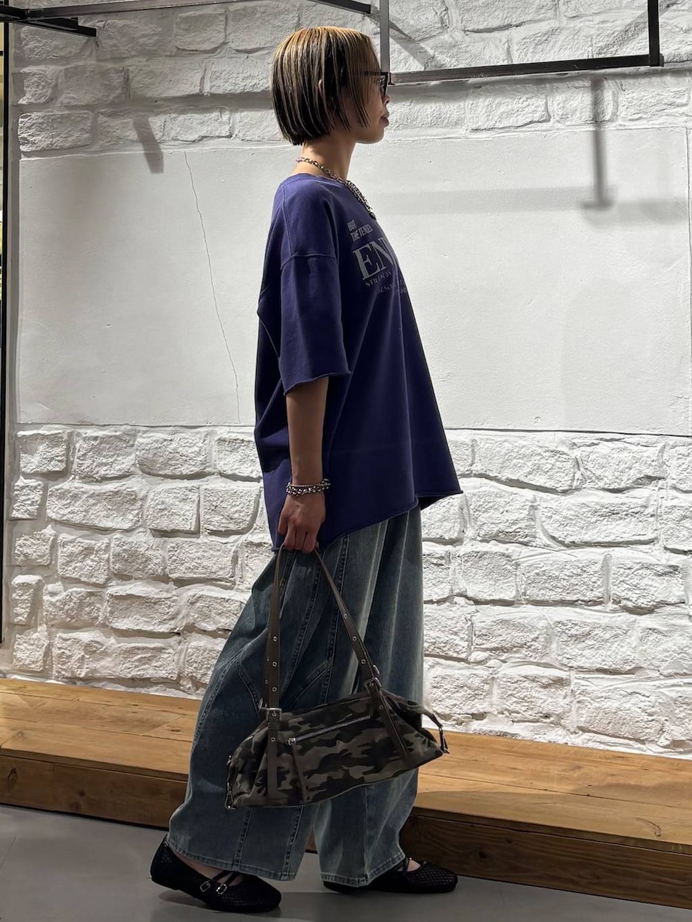 ブルー系のデニムパンツ、ブラック系のパンプス、その他のトートバッグを着用したレディースの春コーディネートの4枚目の写真