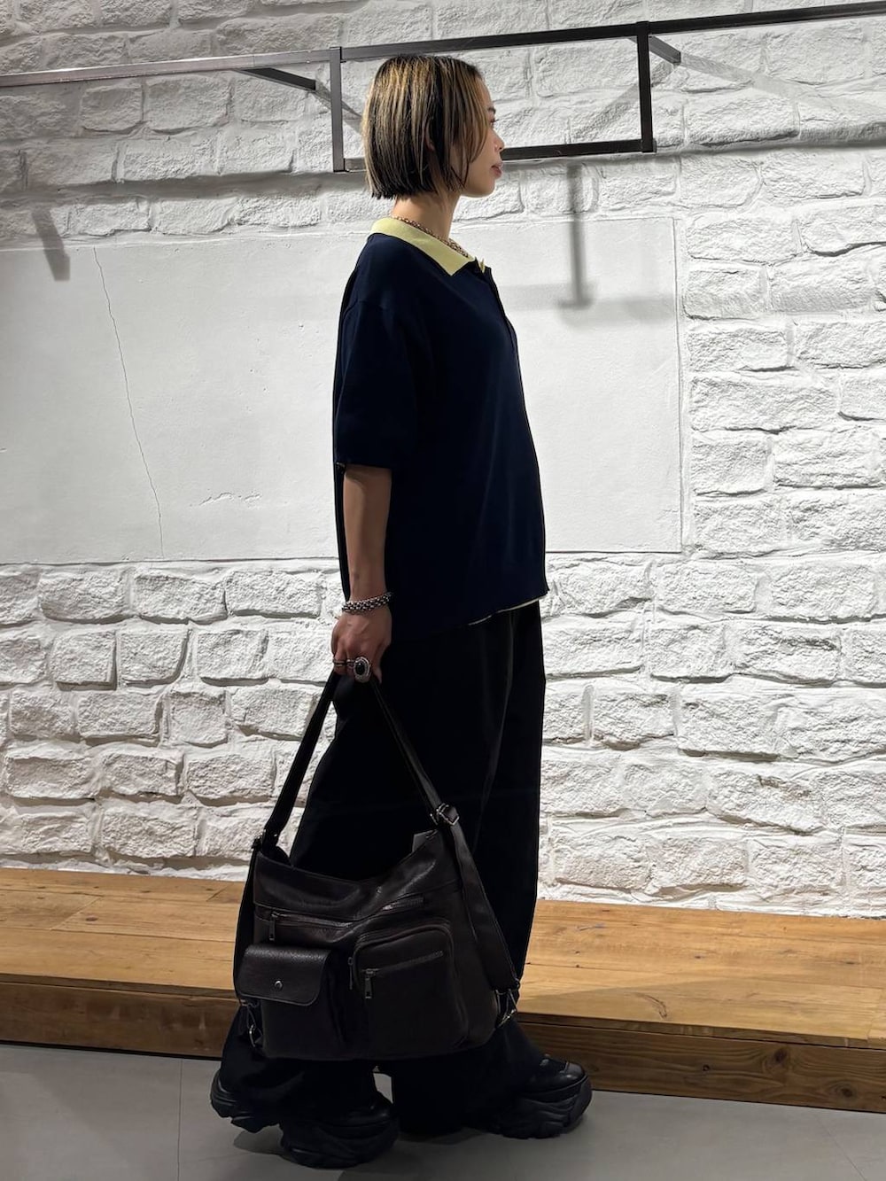 ブルー系のポロシャツ、ブラック系のカーゴパンツ、ブラック系のスニーカーを着用したレディースの夏コーディネートの5枚目の写真