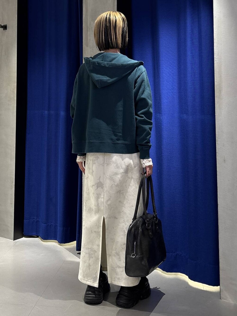 ブラック系のブーツ、ブラック系のボストンバッグ、ホワイト系のTシャツ/カットソーを着用したレディースの冬コーディネートの6枚目の写真