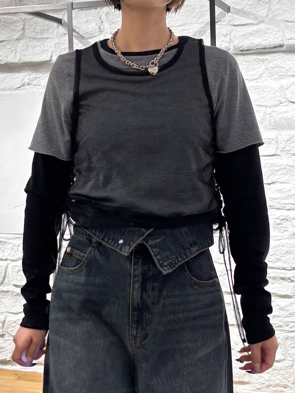 ブラック系のスニーカー、ブルー系のデニムパンツ、ブルー系のショルダーバッグを着用したレディースの秋コーディネートの3枚目の写真