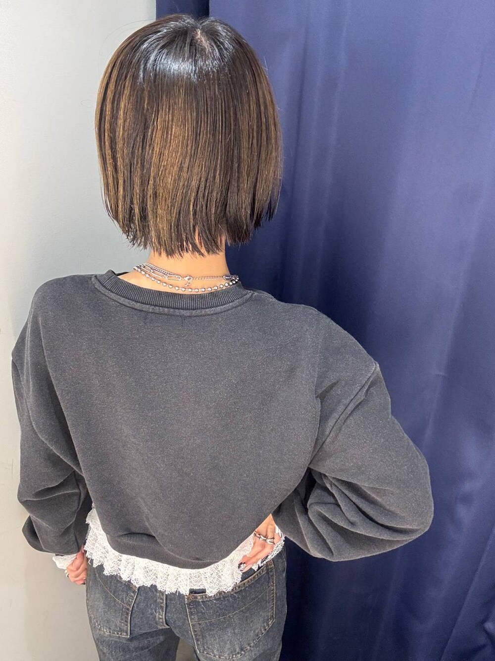 ホワイト系のTシャツ/カットソー、ブラック系のスニーカー、ブルー系のデニムパンツを着用したレディースの秋コーディネートの3枚目の写真