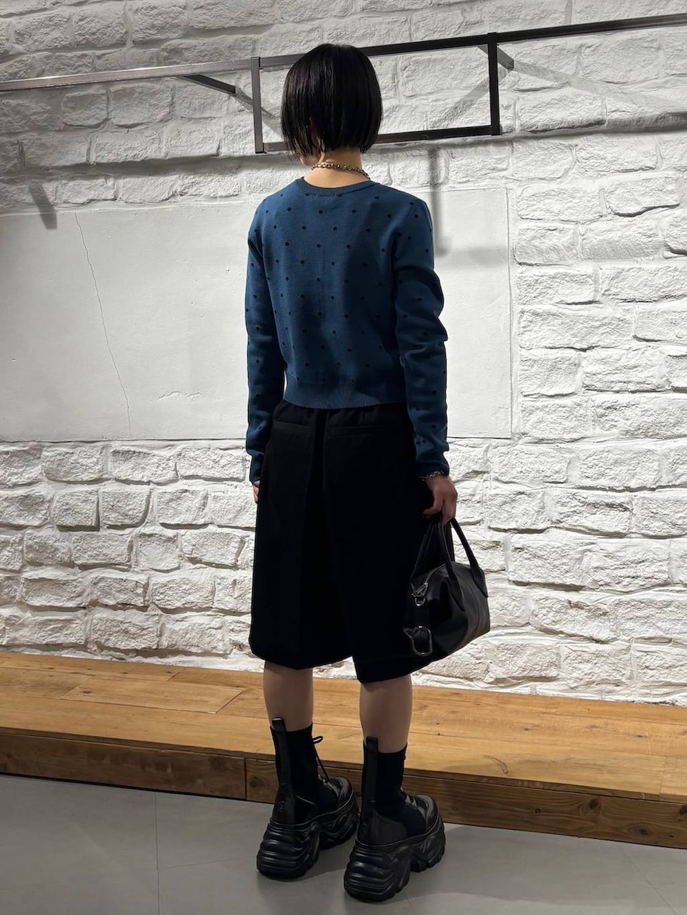 ブラック系のショルダーバッグ、ブラック系のその他パンツ、ブルー系のカーディガン/ボレロを着用したレディースの秋コーディネートの5枚目の写真