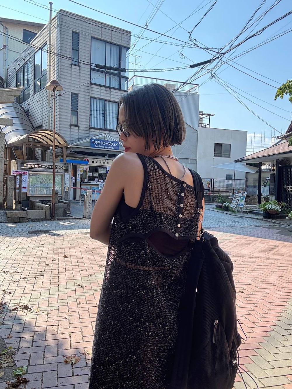 ブラウン系のデニムパンツ、ブラック系のサンダル、ブラック系のワンピースを着用したレディースの夏コーディネートの6枚目の写真