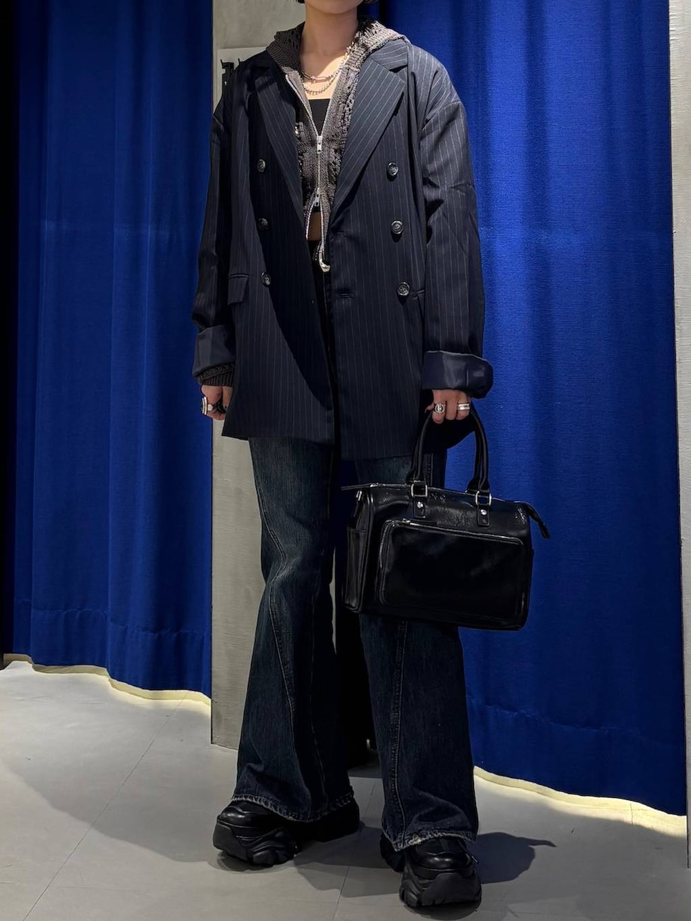 ブラック系のスニーカー、ブラック系のキャミソール、ブルー系のデニムパンツを着用したレディースの春コーディネートの2枚目の写真