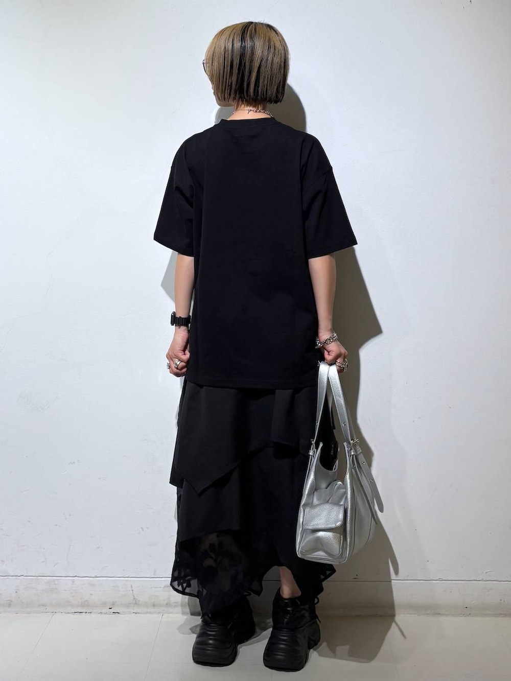 ブラック系のスニーカー、シルバー系のハンドバッグ、ブラック系のTシャツ/カットソーを着用したレディースの夏コーディネートの4枚目の写真