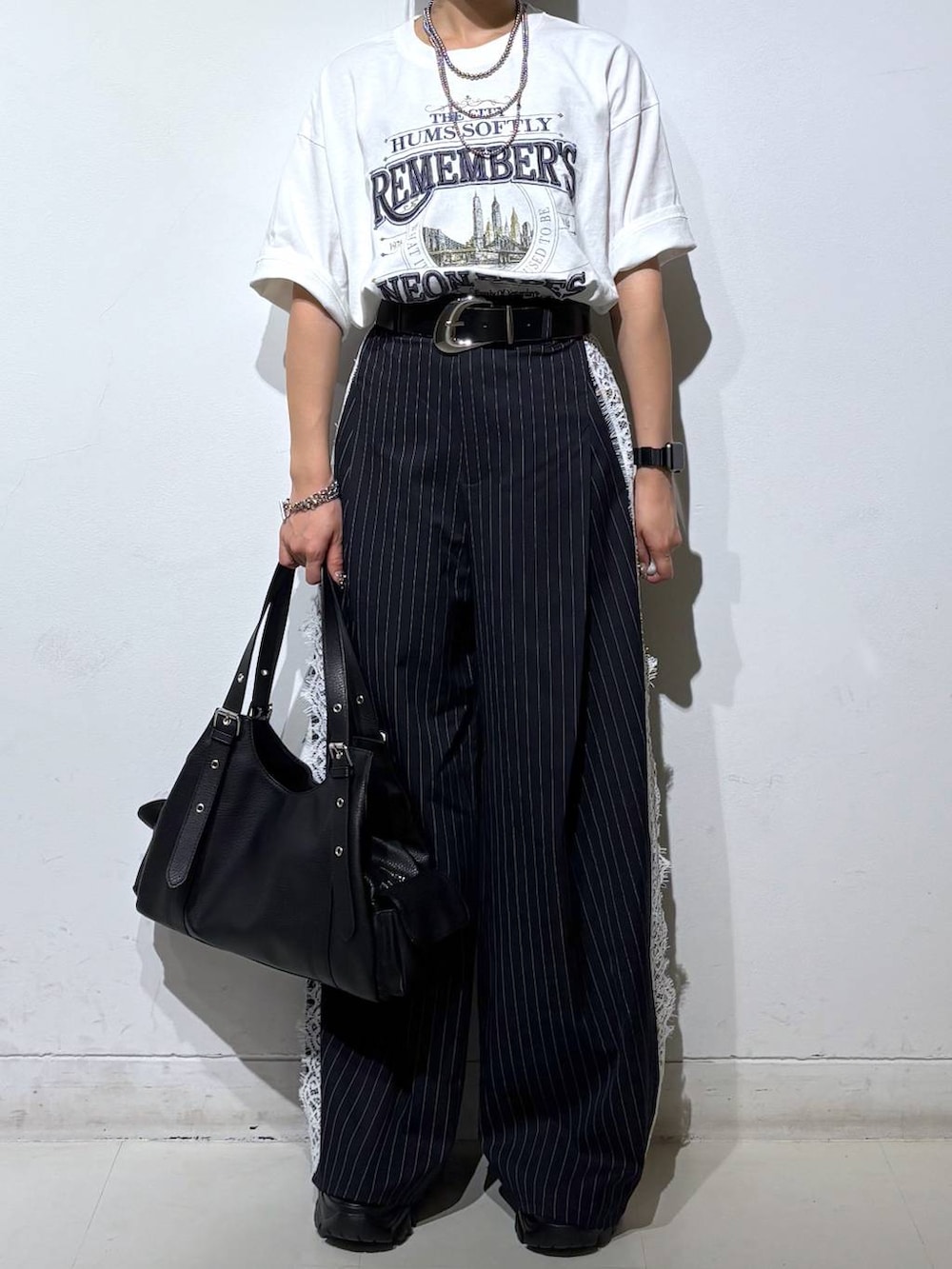 ブラック系のサンダル、ホワイト系のTシャツ/カットソー、ブルー系のスラックスを着用したレディースの夏コーディネートの3枚目の写真