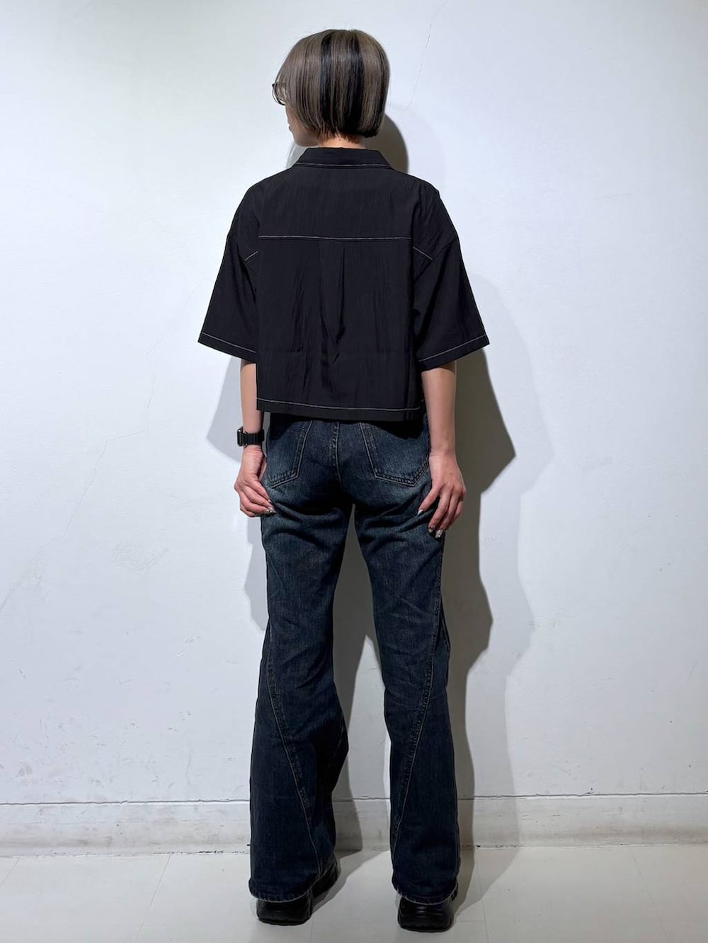 ブルー系のデニムパンツ、ホワイト系のタンクトップ、グレー系のサンダルを着用したレディースの春コーディネートの5枚目の写真