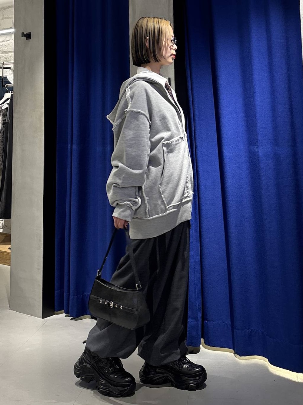 ブラック系のスニーカー、ブラック系のハンドバッグ、グレー系のその他パンツを着用したレディースの冬コーディネートの3枚目の写真