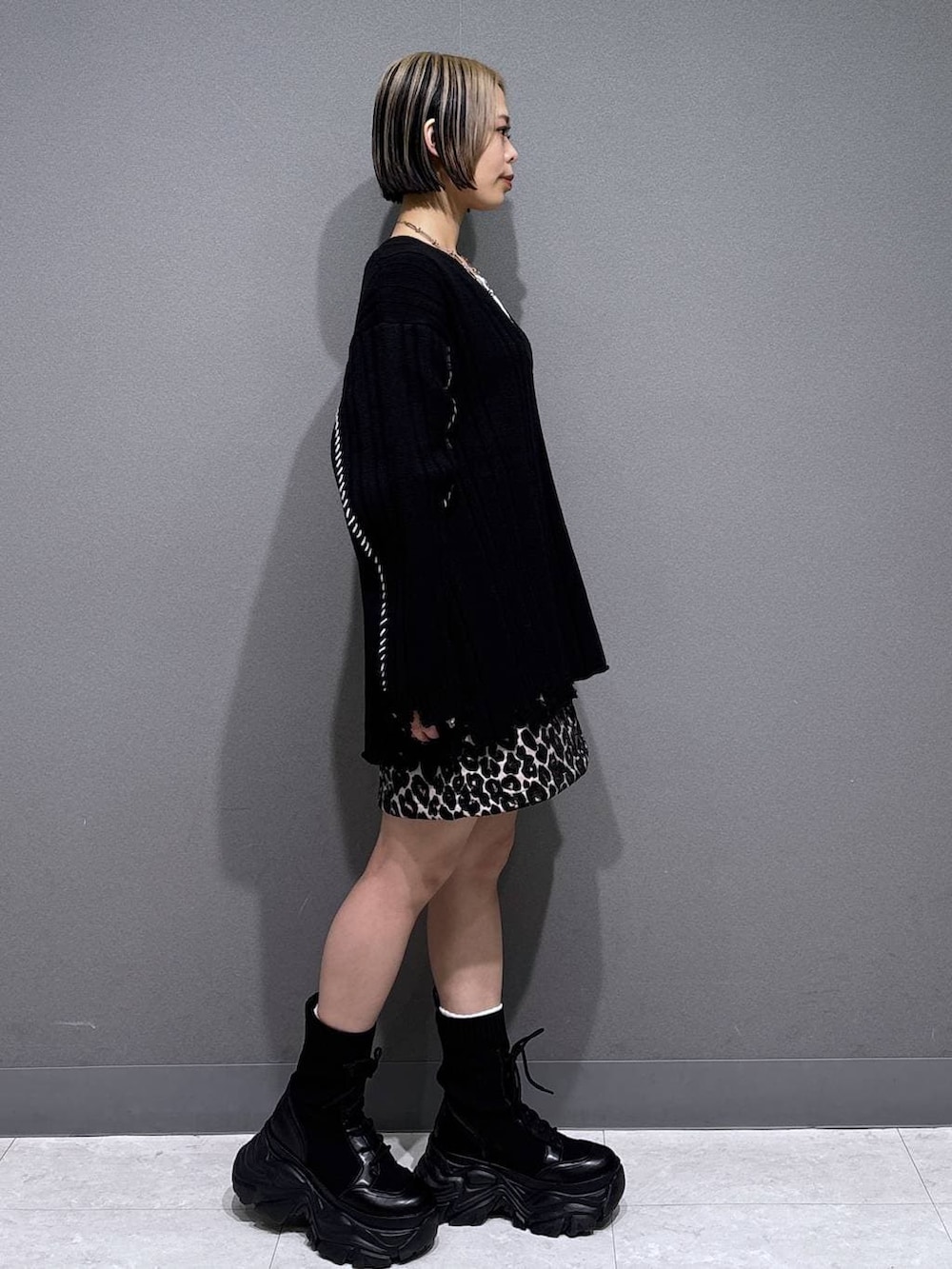 ブラック系のブーツ、ホワイト系のTシャツ/カットソー、ブラウン系のスカートを着用したレディースの冬コーディネートの3枚目の写真