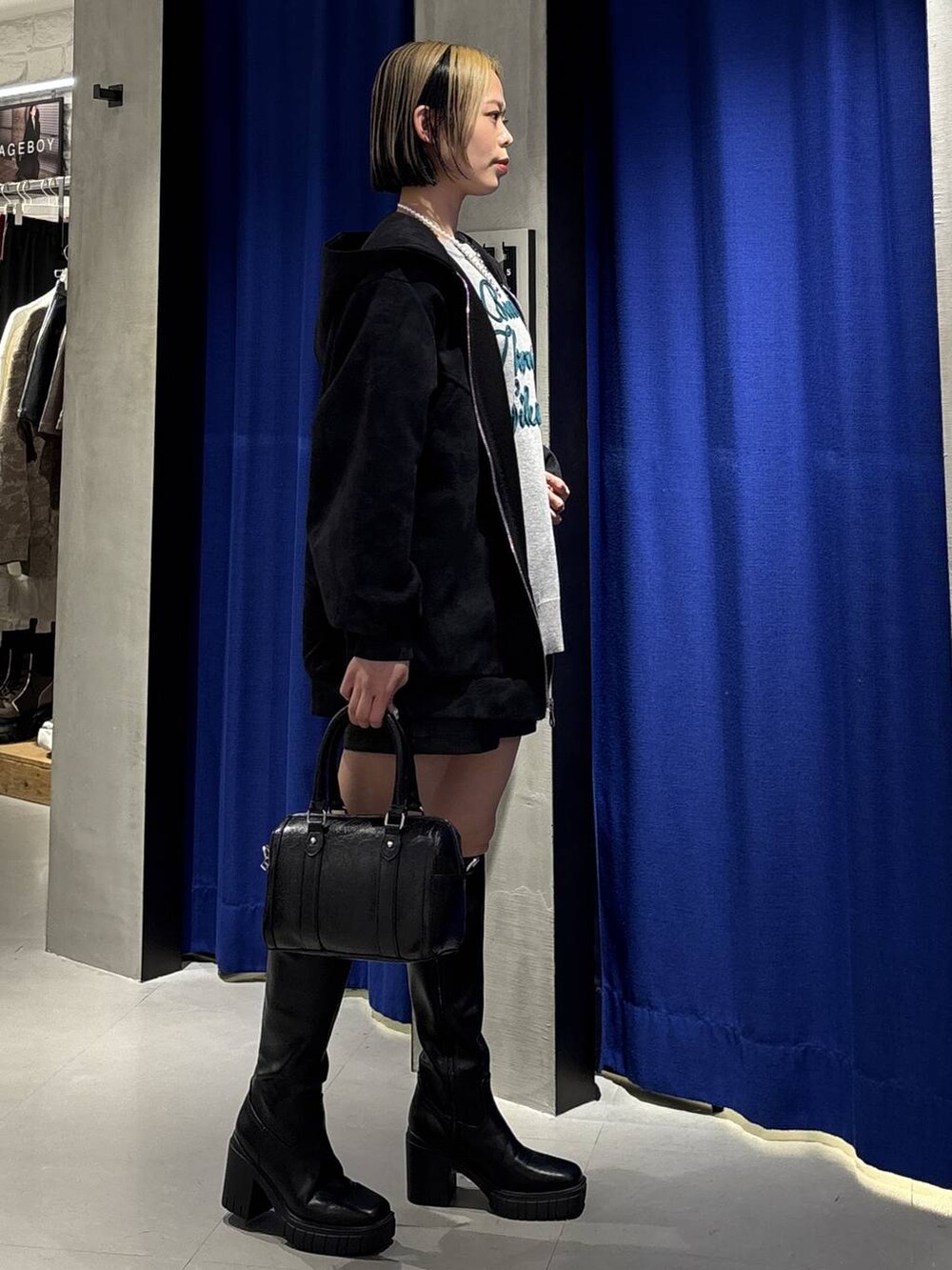 ブラック系のブーツ、ブラック系のその他パンツ、ブラック系のボストンバッグを着用したレディースの冬コーディネートの4枚目の写真