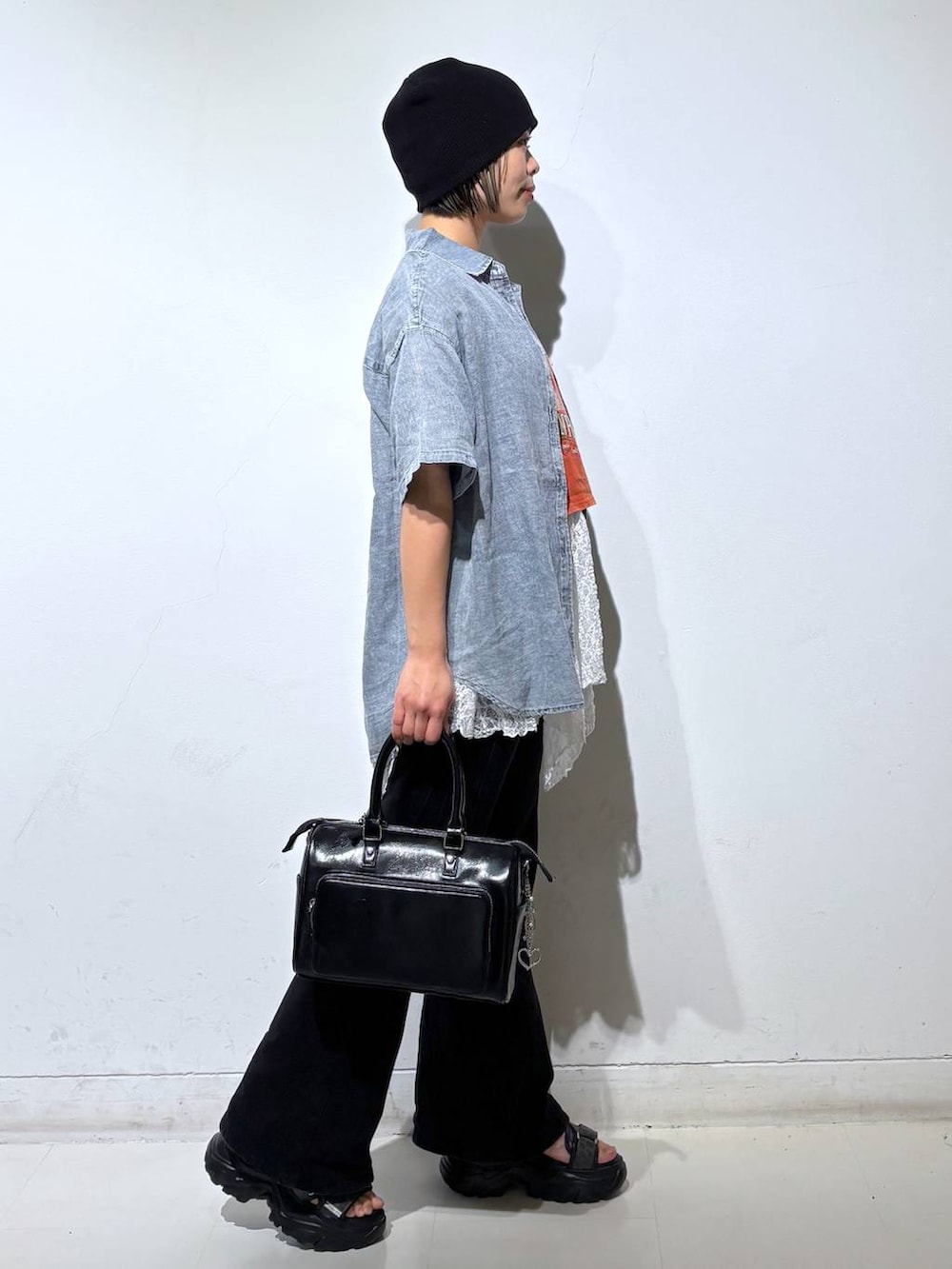 ブラック系のデニムパンツ、ブラック系のショルダーバッグ、ブルー系のシャツ/ブラウスを着用したレディースの春コーディネートの4枚目の写真