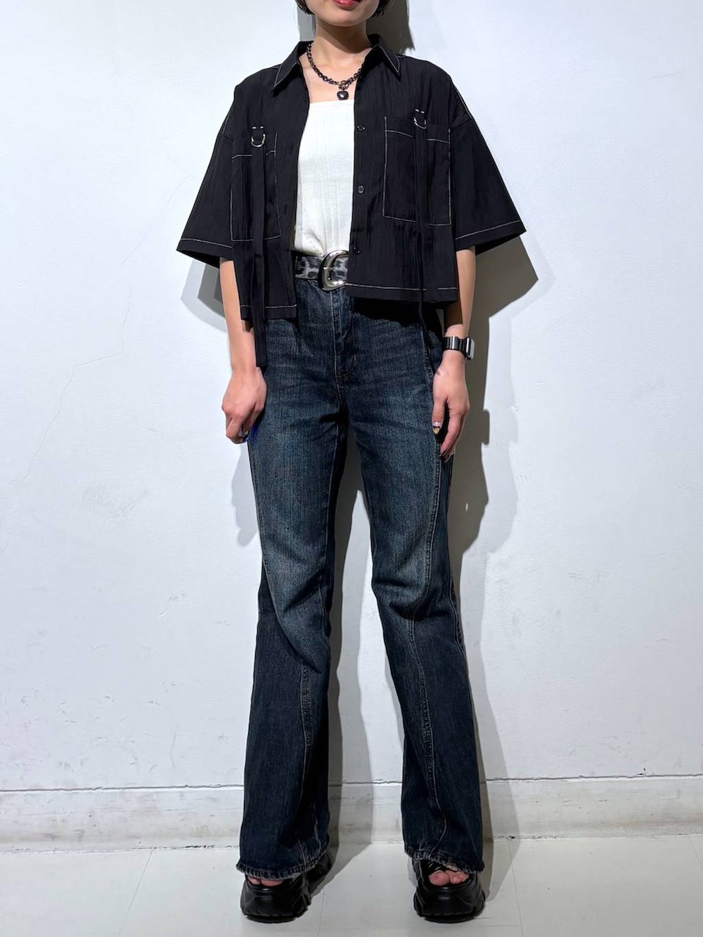 ブルー系のデニムパンツ、ホワイト系のタンクトップ、グレー系のサンダルを着用したレディースの春コーディネートの3枚目の写真