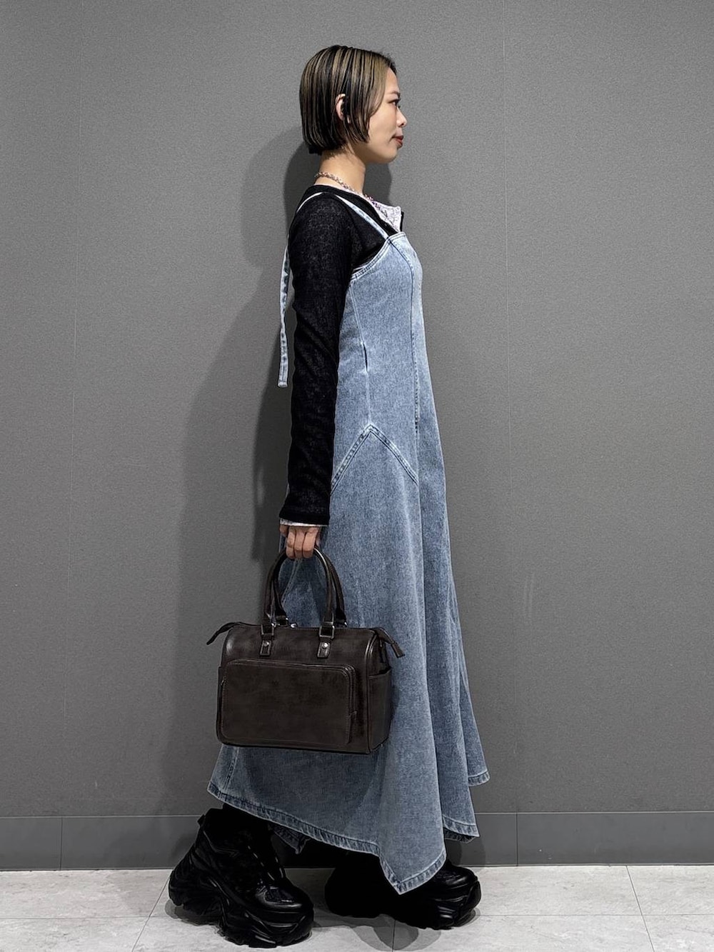 ブラック系のスニーカー、グレー系のショルダーバッグ、ブルー系のワンピースを着用したレディースの春コーディネートの4枚目の写真