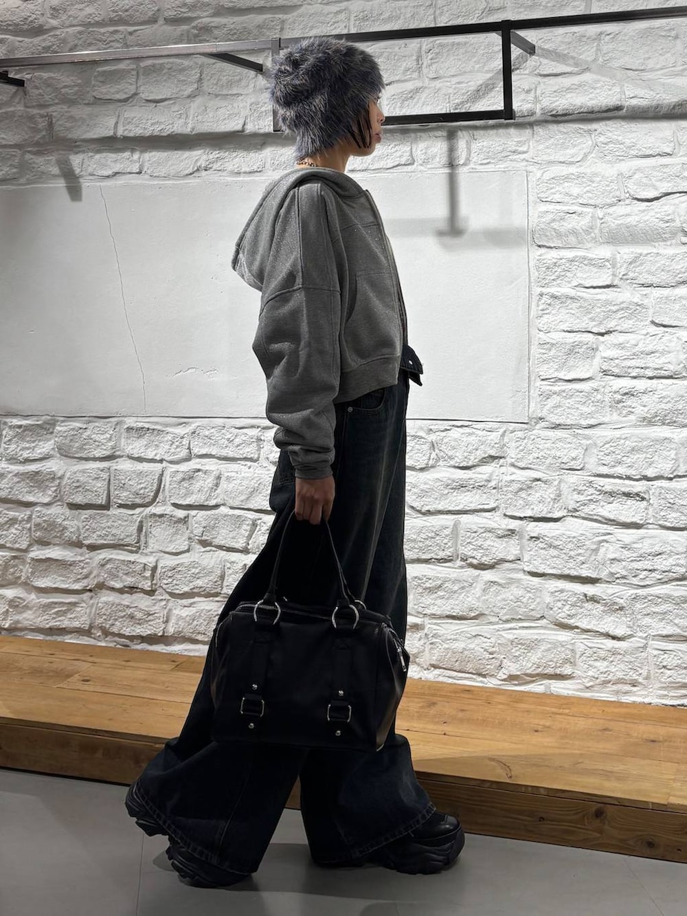 ブルー系のデニムパンツ、ブラック系のボストンバッグ、グレー系のパーカーを着用したレディースの秋コーディネートの5枚目の写真