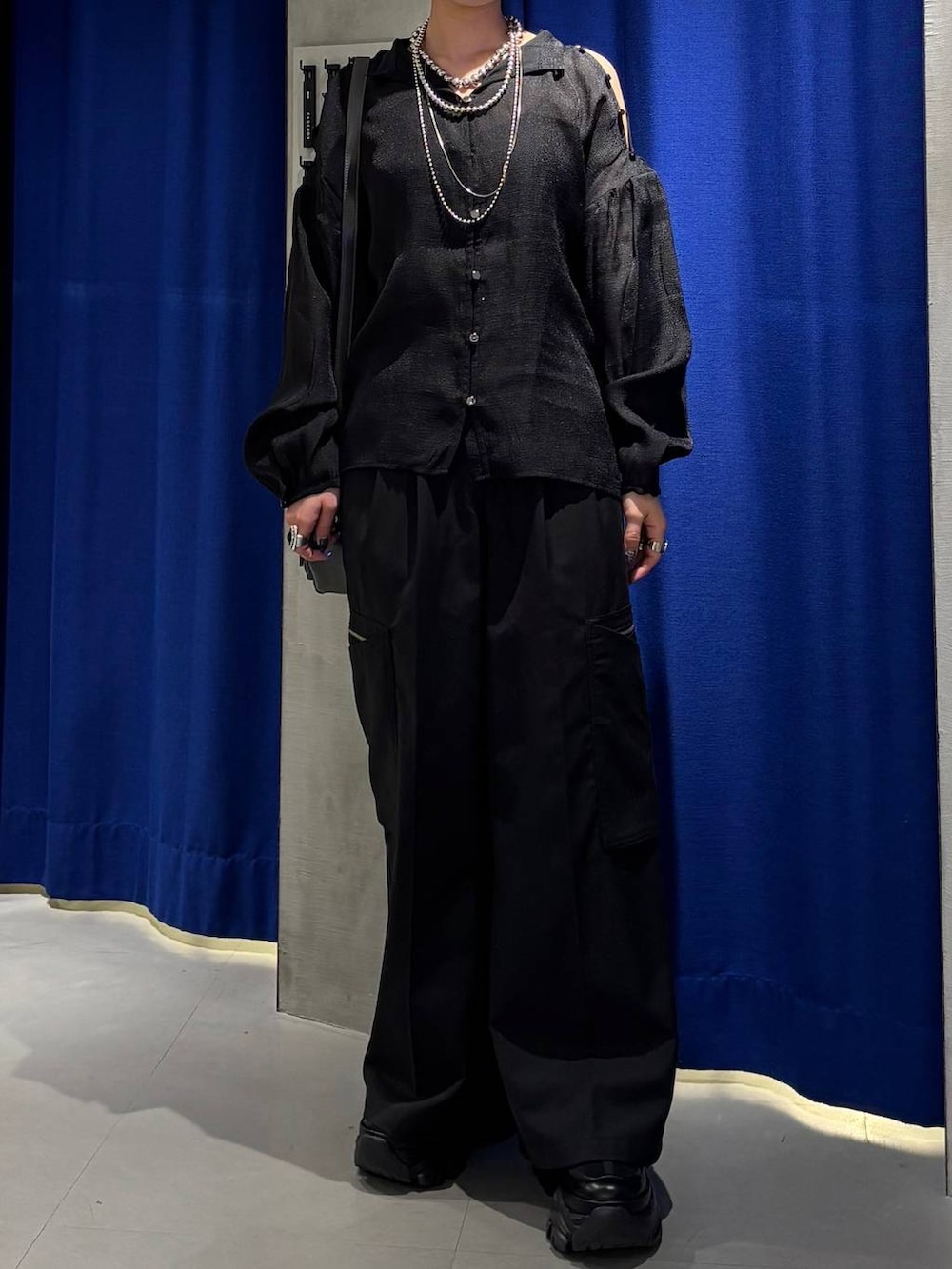 ブラック系のスニーカー、ブラック系のスラックス、グレー系のショルダーバッグを着用したレディースの春コーディネートの2枚目の写真