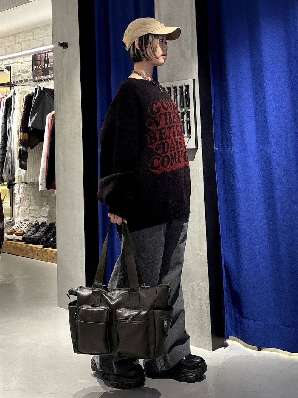 ブラック系のスニーカー、グリーン系のボストンバッグ、ブラック系のニット/セーターを着用したレディースの冬コーディネートの3枚目の写真