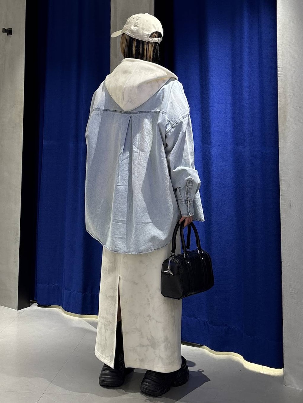 ブラック系のブーツ、ホワイト系のTシャツ/カットソー、ホワイト系のスカートを着用したレディースの冬コーディネートの5枚目の写真