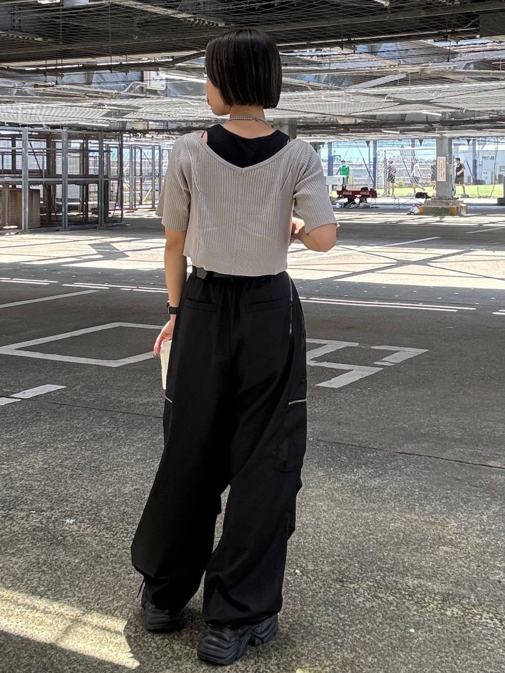 ブラック系のカーゴパンツ、グレー系のTシャツ/カットソー、ブラック系のスニーカーを着用したレディースの夏コーディネートの6枚目の写真