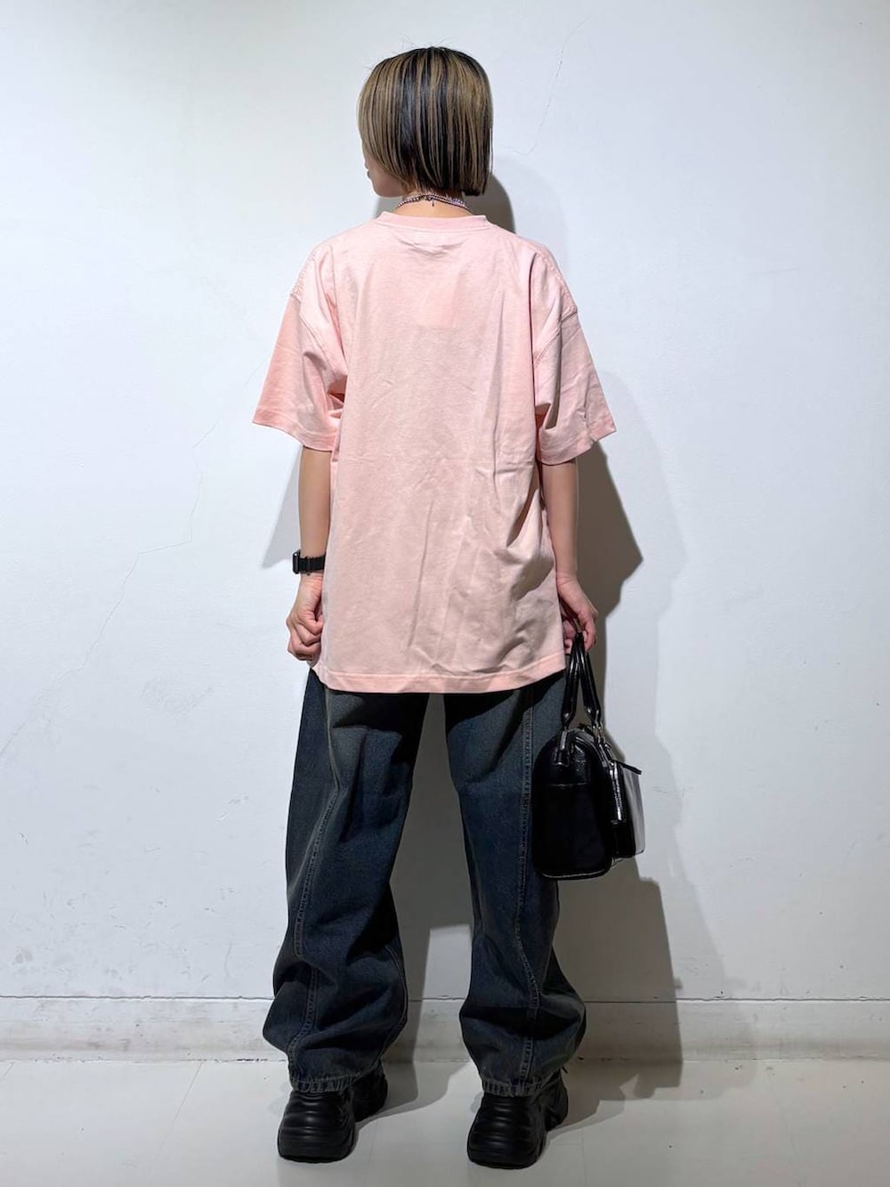 ブラック系のスニーカー、ブルー系のデニムパンツ、ブラック系のショルダーバッグを着用したレディースの春コーディネートの5枚目の写真