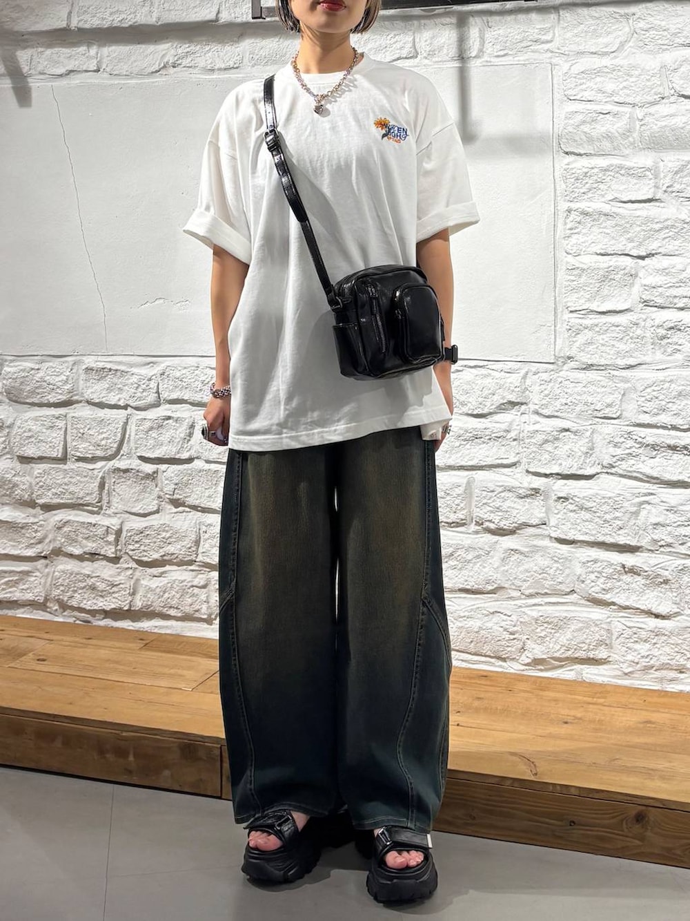 グリーン系のデニムパンツ、ブラック系のショルダーバッグ、グレー系のサンダルを着用したレディースの夏コーディネートの3枚目の写真