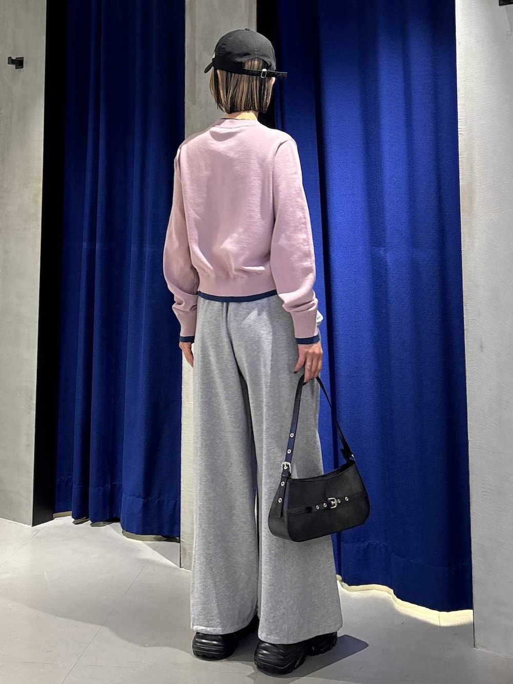 ブラック系のブーツ、グレー系のスウェットパンツ、ブラック系のハンドバッグを着用したレディースの春コーディネートの4枚目の写真