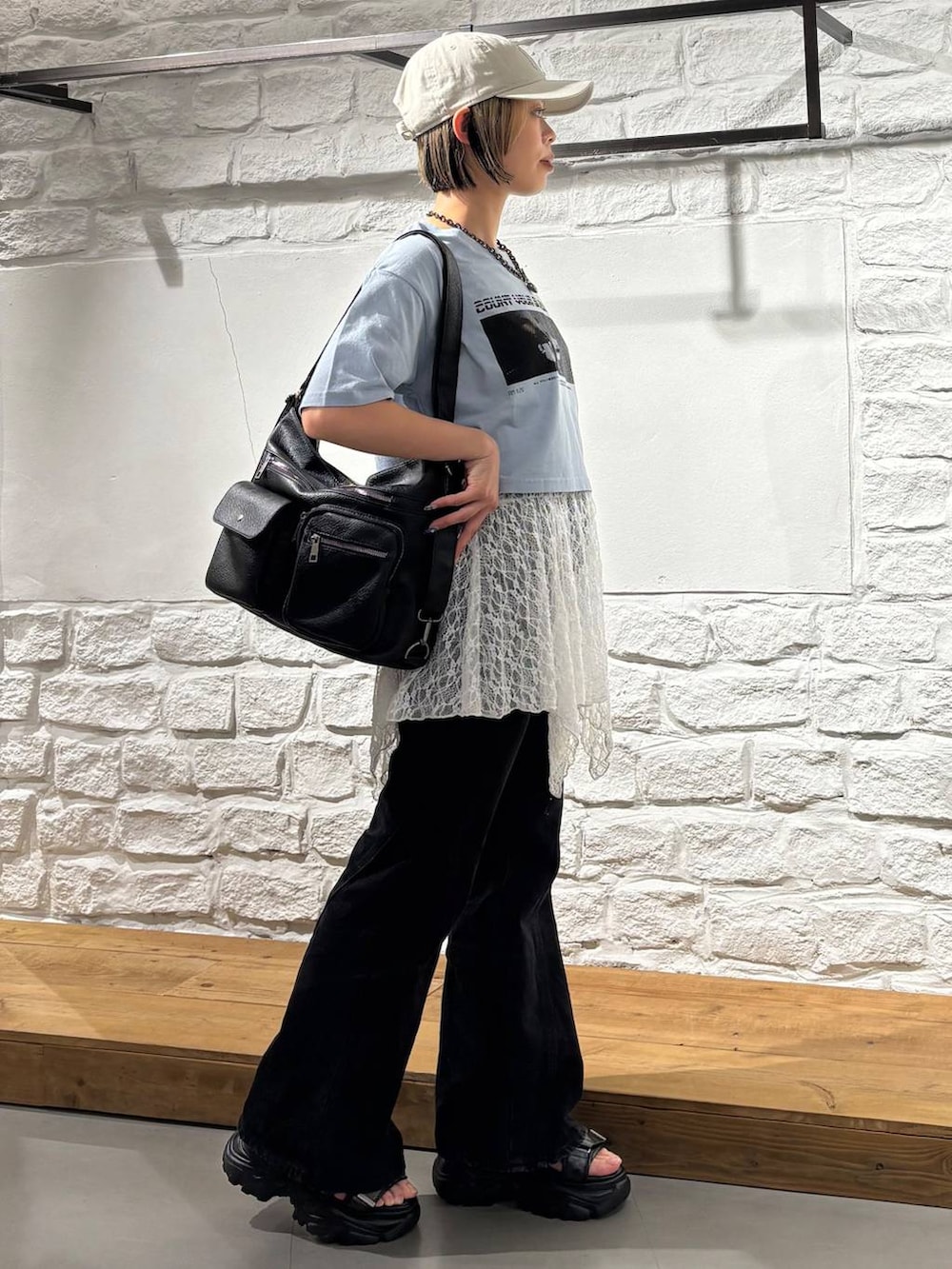 ブルー系のTシャツ/カットソー、ブラック系のデニムパンツ、ブラック系のショルダーバッグを着用したレディースの夏コーディネートの5枚目の写真