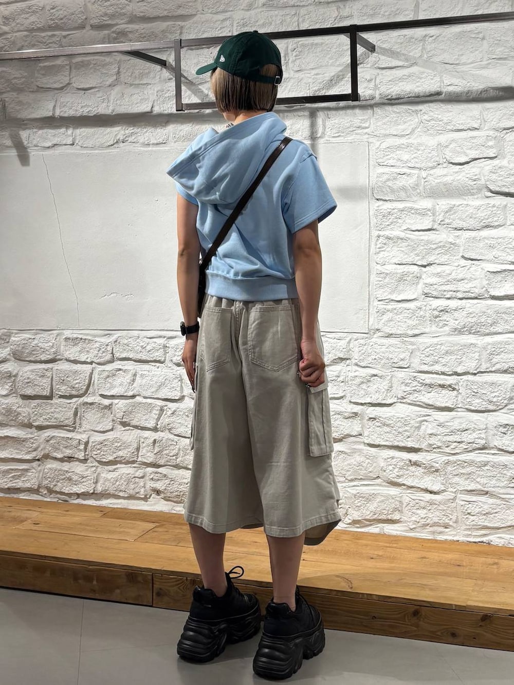 ブラック系のスニーカー、ブラウン系のショルダーバッグ、ブルー系のパーカーを着用したレディースの夏コーディネートの5枚目の写真