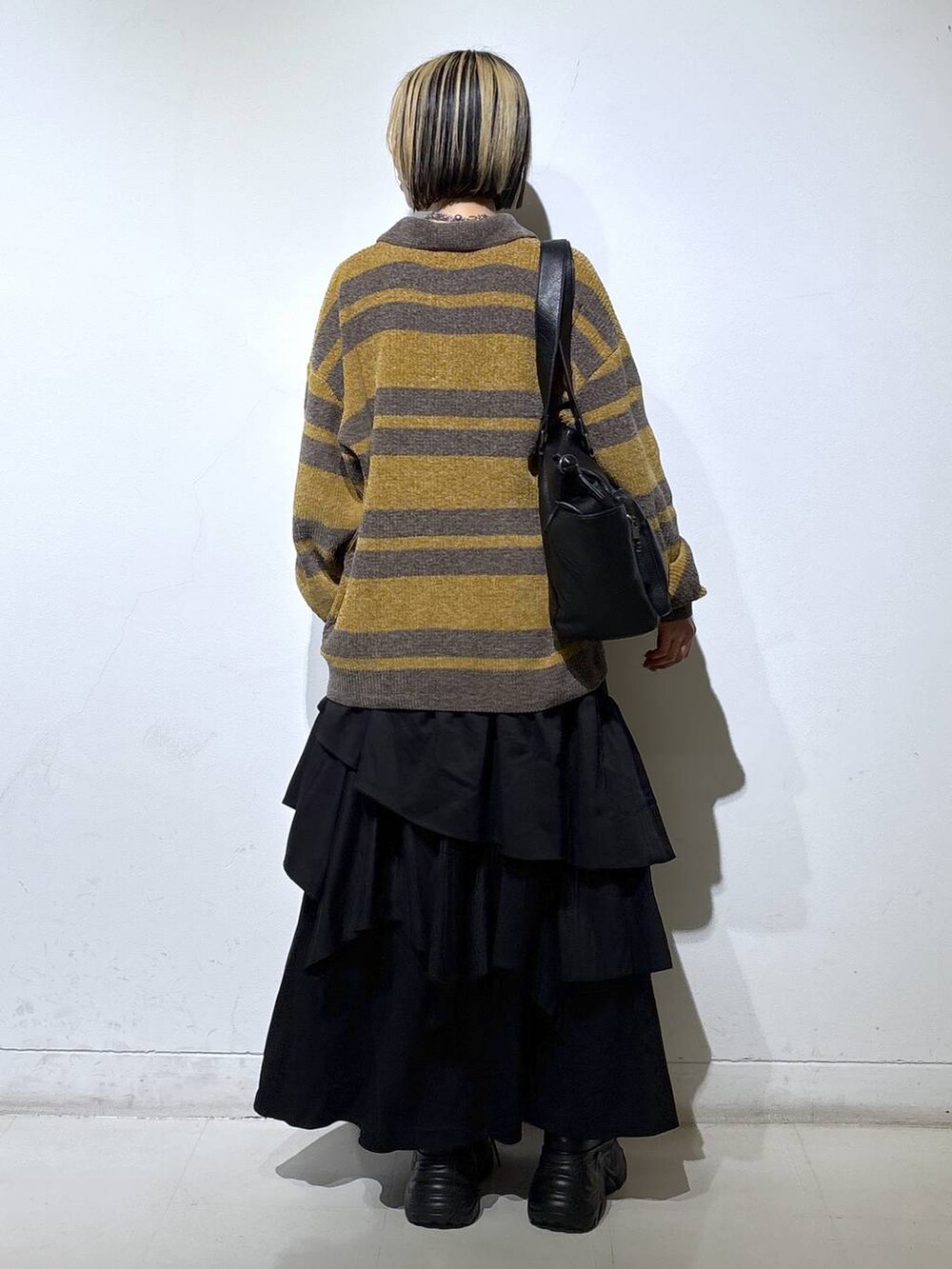 ブラック系のブーツ、ブラック系のボストンバッグ、ブラック系のスカートを着用したレディースの秋コーディネートの4枚目の写真