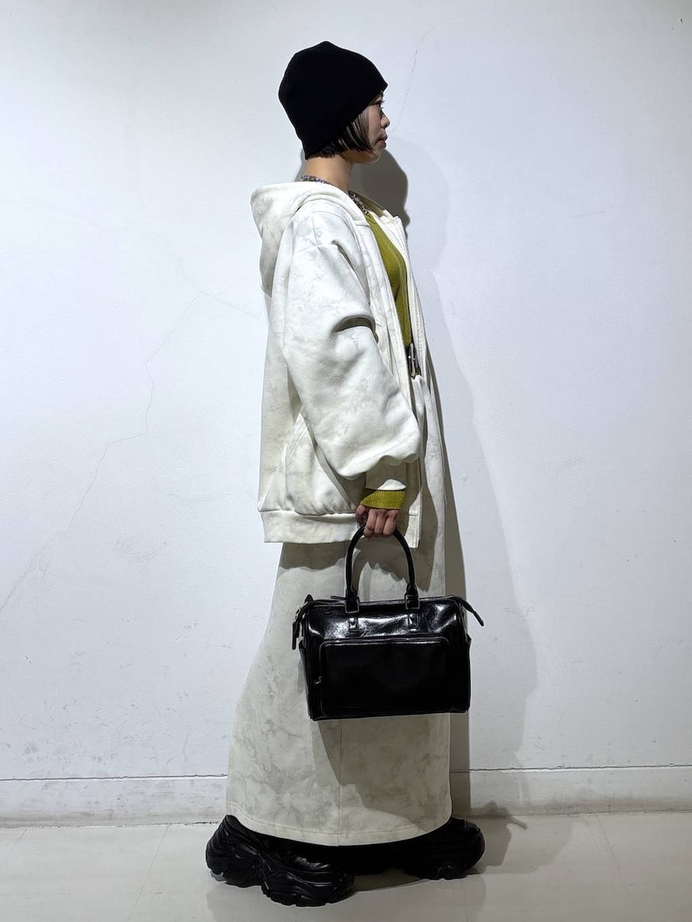 ブラック系のブーツ、ホワイト系のパーカー、ホワイト系のスカートを着用したレディースの冬コーディネートの4枚目の写真