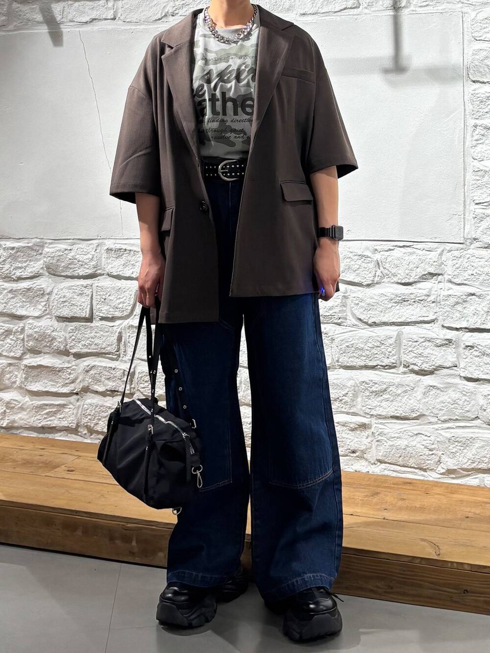 ブラック系のスニーカー、ブルー系のデニムパンツ、その他のTシャツ/カットソーを着用したレディースの春コーディネートの3枚目の写真