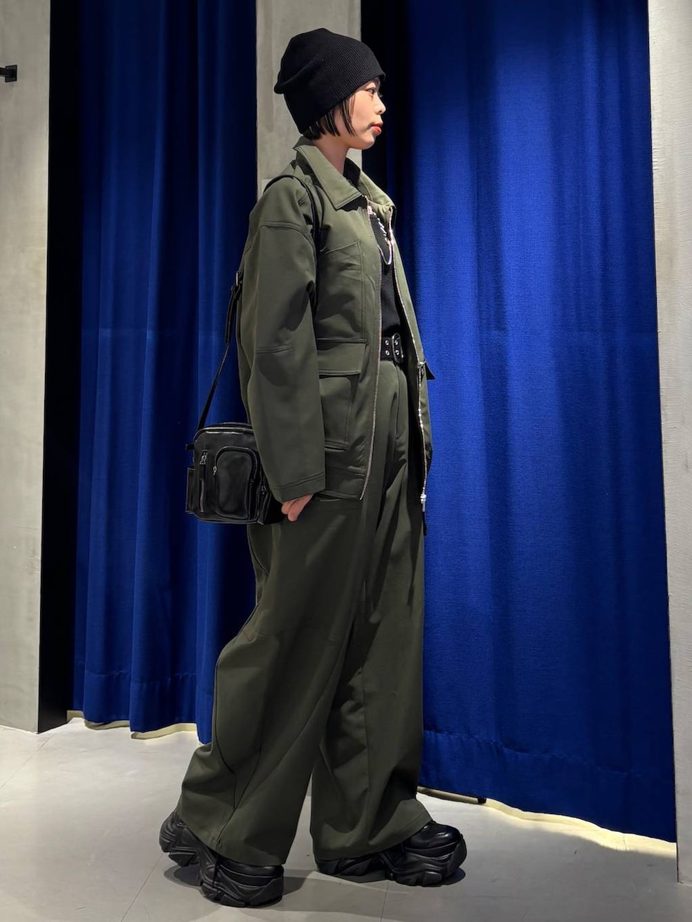 ブラック系のスニーカー、ブラック系のタンクトップ、グリーン系のカーゴパンツを着用したレディースの春コーディネートの5枚目の写真